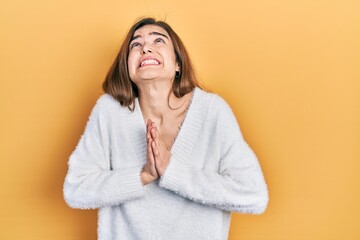 Young caucasian girl wearing casual clothes begging and praying with hands together with hope expression on face very emotional and worried. begging.