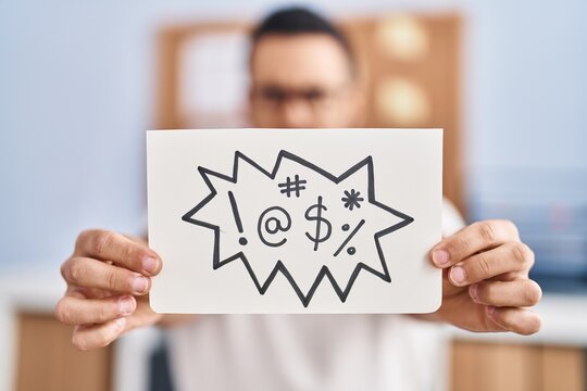 Young hispanic man business worker holding onomatopeia shout message at office
