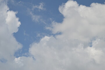 Obraz premium Large puffy white clouds on clear blue sky 