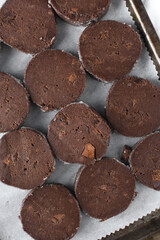 Chocolate palet breton cookies, chocolate sable cookies, french chocolate butter cookies, raw palet breton cookies sliced and placed on a parchment lined baking sheet 