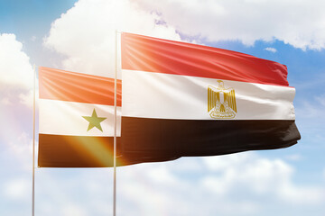 Sunny blue sky and flags of egypt and syria