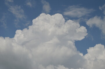 Naklejka na ściany i meble Large puffy white clouds on clear blue sky 