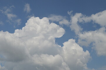 Naklejka na ściany i meble Large puffy white clouds on clear blue sky 