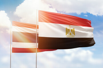 Sunny blue sky and flags of egypt and thailand