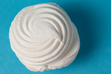 White marshmallow on a blue background close-up.