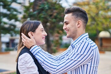 Obraz premium Man and woman couple smiling confident hugging each other at park