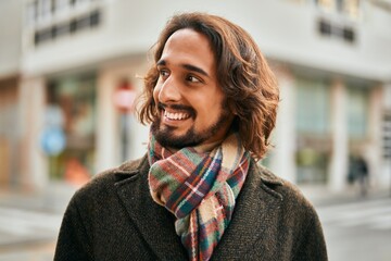 Young hispanic man smiling happy standing at the city.