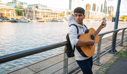 the guy plays with the guitar near the river