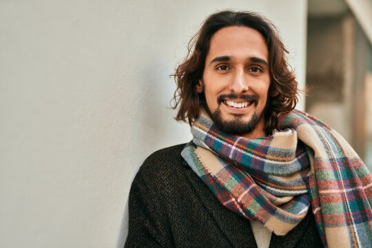 Young hispanic man smiling happy standing at the city.