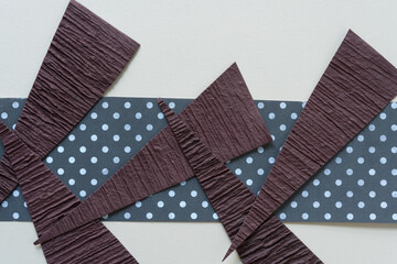 brown paper triangles arranged on a paper background (some with polka dots)