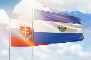 Sunny blue sky and flags of el salvador and slovakia