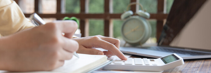 Head of accounting is recording the company's financial growth statistics using graphs as a reference for reviewing and analyzing the results, Taking notes and analyzing data graphs in office.