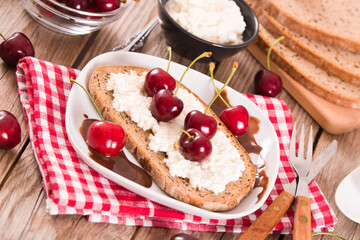 Rye bread with cottage cheese and cherries.