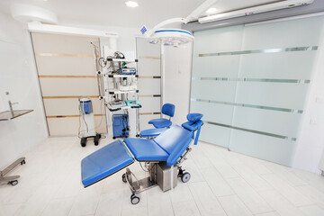 light surgical dental cabinet with a blue chair and a rack with equipment