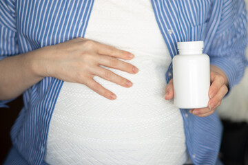 vitamins for expectant mothers, a pregnant woman holds a jar of pills in her hands, health and medicine in pregnancy