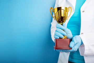 medical award, golden cup in doctor's hands, healthcare and medicine