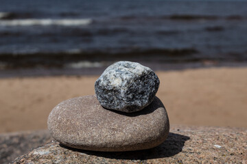 White-gray stone on a beige stone on a sea background. Concept of relax, meditation.2022.