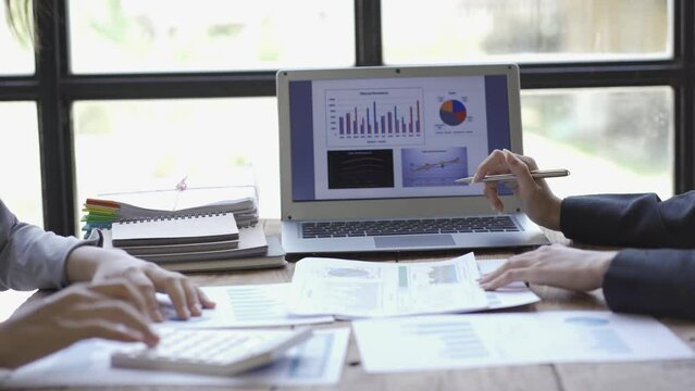 Investment advisor 2 business people analyze company financial statements working with document graphs for stock market, office, tax and project team of data analysts working with tablet computers.