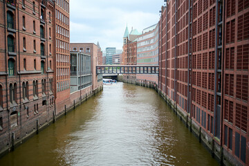 Naklejka premium View of famous Speicherstadt warehouse district. Old brick building, river canal of Hafencity quarter. Hamburg skyline.