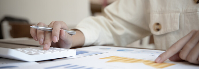 Accounting businesswomen are calculating income-expenditure and analyzing real estate investment data, Dedicated to the progress and growth of the company, Financial and tax systems concept.