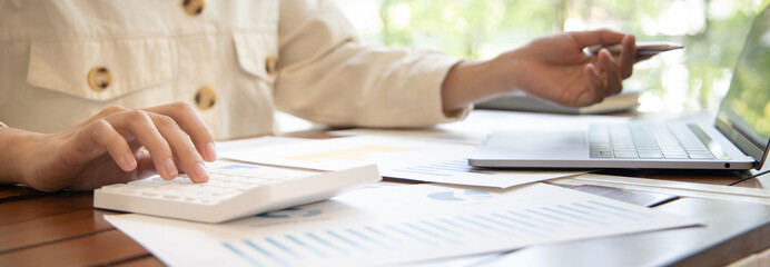 Financial businesswomen use laptop to analyze marketing strategies and real estate data to reduce...