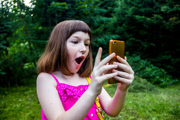 a little girl taking selfie at nature near the forest