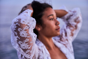 portrait of a vietnamese young girl posing at the sunset behind the sea at the beach on summertime