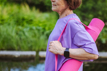 An old slender woman does yoga in the park