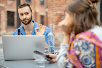 Stylish man talks with his female colleague at cafe