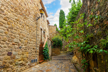 The wet streets of the medieval village of Pals, Spain after a summer rainstorm along the Costa...