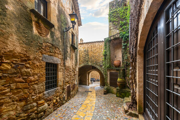 The wet streets of the medieval village of Pals, Spain after a summer rainstorm along the Costa...