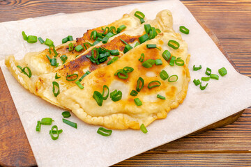 Uzbek,Tatar cuisine,cheburek with beef,pork meat,onions,greens on wooden board.Fresh baked homemade Cornish pasties,fried stews pie wrapped in shortcrust pastry.Traditional Turkish mongolian dish