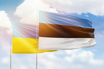 Sunny blue sky and flags of estonia and ukraine