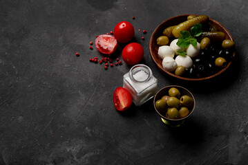 Products for cooking pizza and salad on a dark background. vegetables, sauces and herbs with spices. Place for text.