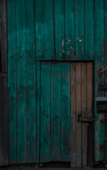 Old dark wooden rustic look barn doors. Metal hinges, and lock holders placed on the rough texture doors are very rusty.