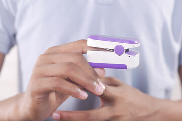 close up of man hand using pulse oximeter