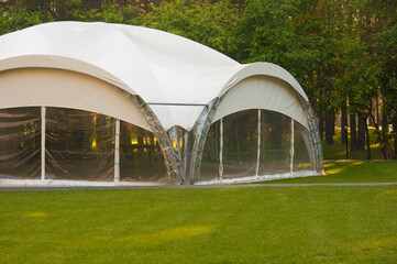 Naklejka premium large camping tent stands in shade of pine forest, weather is sunny. Summer camp, rest, hike. Side view.