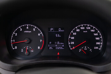 Fototapeta premium Modern car illuminated dashboard closeup. White arrows on Speedometer