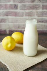  milk jar and yellow lemon on table 