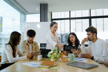 Meeting of Asian business people who are committed to work. Creative business team sitting working together at office.