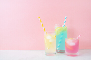 Colorful summer lemonade drinks. Three pastel colors in a cluster with against a pink background.
