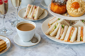 Selection of gourmet cakes and mini canapes with coffee and sparkling wine on a table