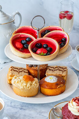Selection of gourmet cakes with coffee and sparkling wine on a table