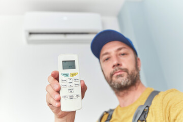 Repairman cleaning and fixing indoors AC unit.