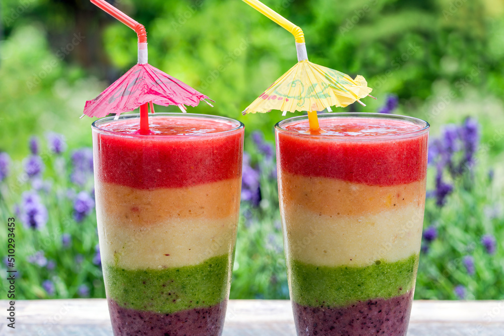 Sticker Rainbow layered fruit smoothie on garden table