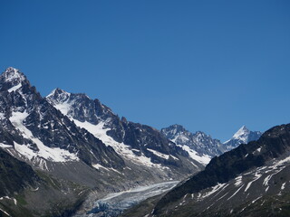 Fototapeta na wymiar secteur Chamonix Mont Blanc, glacier s'écoule vers la vallée avec neige, rochers, parois abruptes