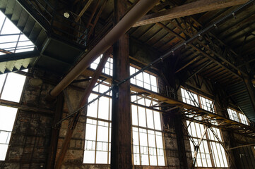 Interior of an abandoned industrial building with large glass windows