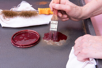 Persona que pinta una chapa oxidada con pintura antioxidante