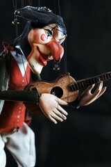Harlequin puppet doll on strings with selective focus