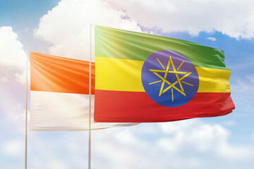 Sunny blue sky and flags of ethiopia and indonesia